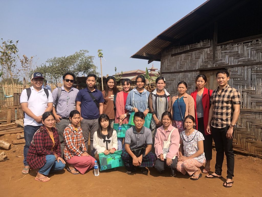 A group of men and women pose outside for a photo