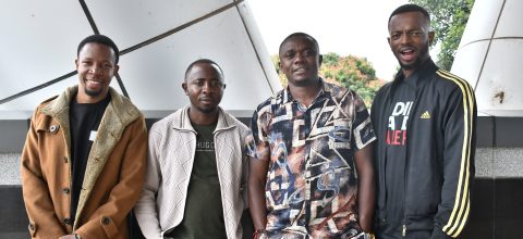 Four men pose for a photo