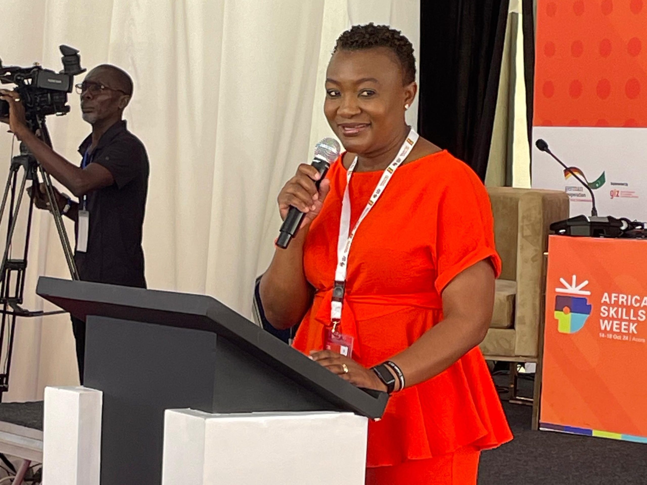 A woman at a podium talks into a microphone