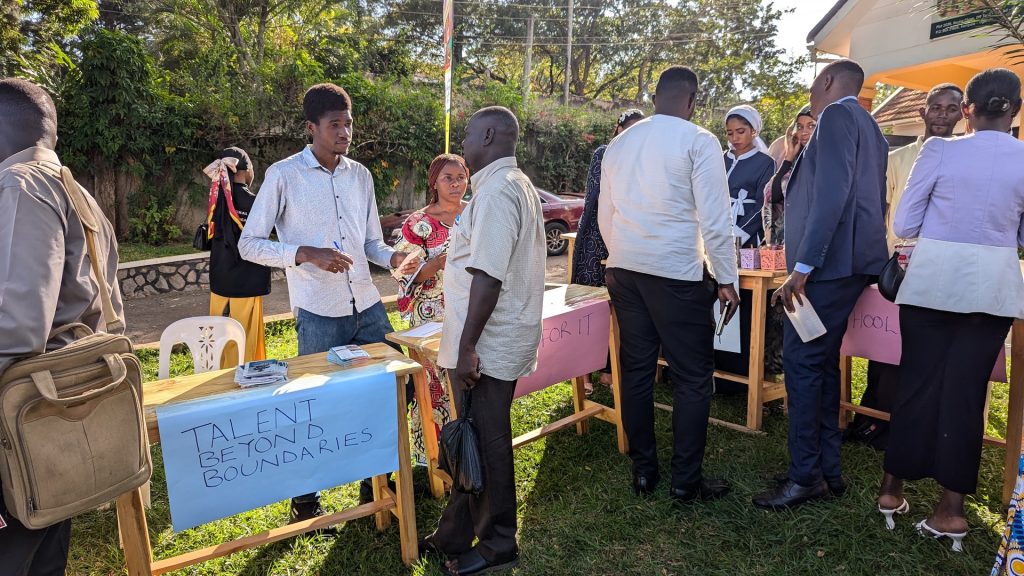 Two people talk over a table during an outside event.