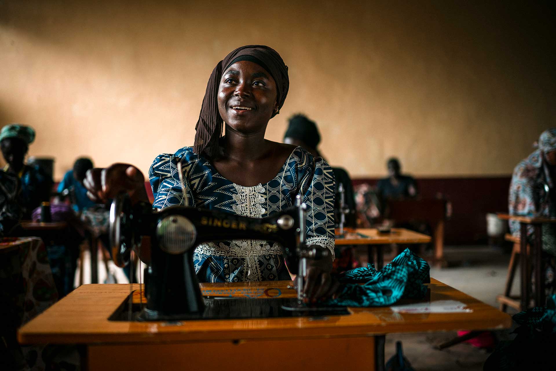 Nuori nainen istuu ompelukoneensa äärellä luokkahuoneessa Keski-Afrikan tasavallassa.