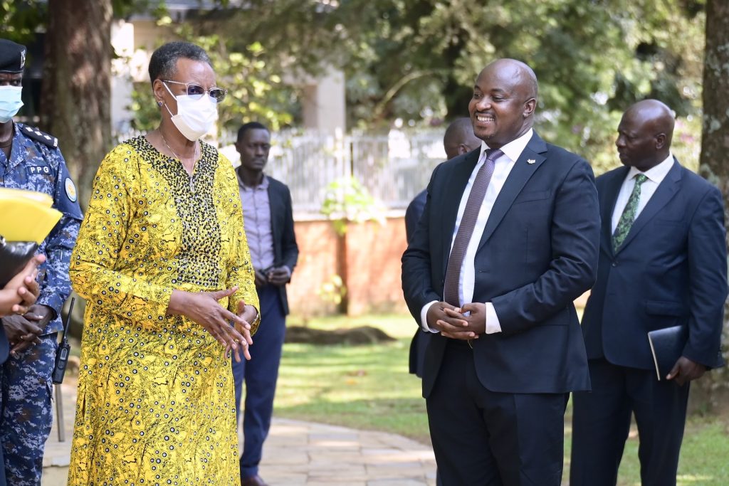 A woman in a medical mask talks to a suited man.