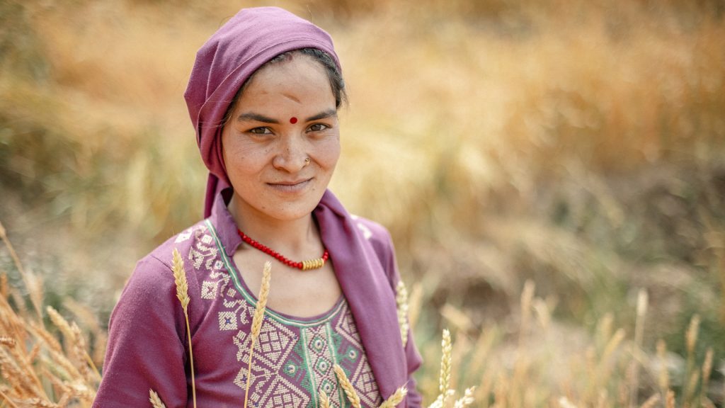 A woman standing on a field in rural Nepal. 